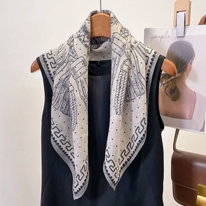Elegant geometric print square silk scarf styled on a black dress with minimalist accessories