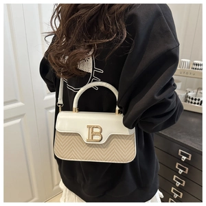 Dettaglio borsa in pelle e paglia a contrasto con fibbia logo B in metallo dorato