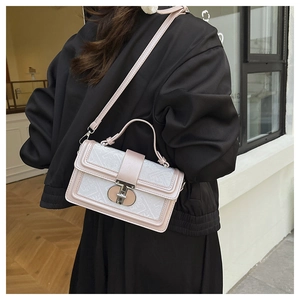 Close-up of a pink jacquard crossbody bag with monogram texture and metallic lock