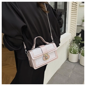 Close-up of pink geometric texture handbag with metal buckle and shoulder strap