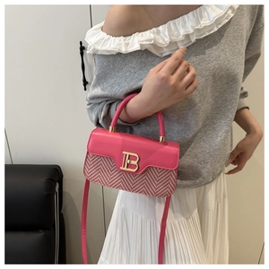 Dettaglio della borsa in pelle rosa con fibbia a B dorata e trama in tessuto a spina di pesce