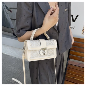 Macro detail of cream structured handbag featuring retro geometric jacquard fabric and metal lock