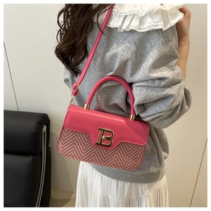 Dettaglio della borsa in pelle rosa con trama intrecciata e fibbia dorata logo B