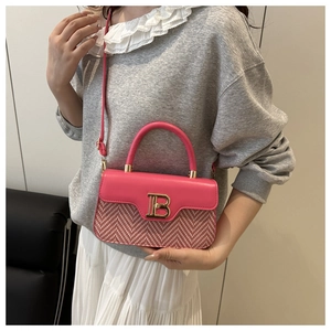 Dettaglio borsa rosa con fibbia dorata logo B e trama a spina di pesce intrecciata