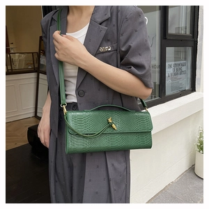 Sac bandoulière vert effet serpent avec boucle nœud métallique et fine lanière en cuir