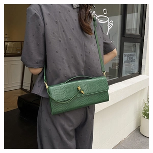 Détail du sac bandoulière vert émeraude à motif serpent avec fermoir doré
