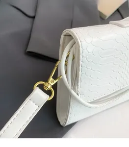 Détail du sac bandoulière blanc motif crocodile avec boucle en métal doré haut de gamme