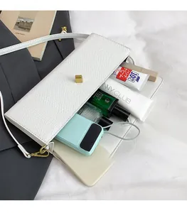 Détail du sac à main blanc motif serpent montrant un intérieur spacieux pour essentiels