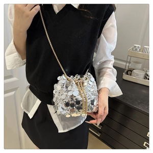 Detail of silver sequin bucket bag with pearl drawstring and golden metal chain strap