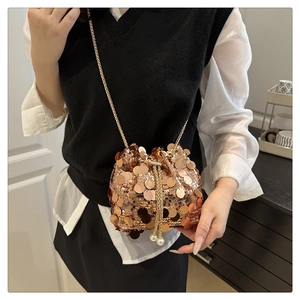 Detailed view of sequin bucket bag with pearl drawstring on a crossbody model