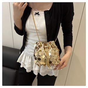 Detail of sequined gold bucket bag with chain strap and drawstring closure for parties