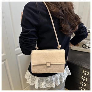 Close-up of beige crocodile pattern small square shoulder bag with a metal buckle