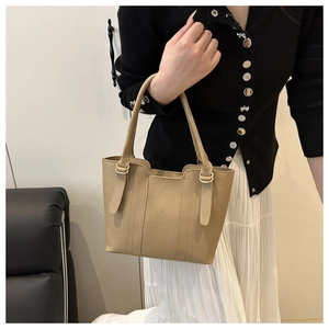 Detail of khaki leather bucket bag with litchi texture and gold metal buckles