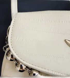 Close-up of white textured leather material and silver metallic stud edge decorations