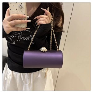 Détail du sac de soirée cylindrique violet avec fermoir perle et chaîne dorée