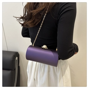 Détail du sac cylindrique en satin violet avec boucle perle et bandoulière chaîne dorée