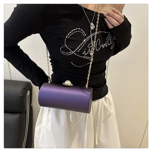 Détail du sac de soirée cylindrique violet avec fermoir perle et chaîne dorée