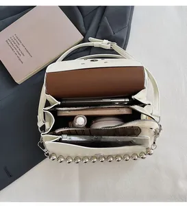 Internal view of white leather crossbody bag with multiple compartments and silver beads