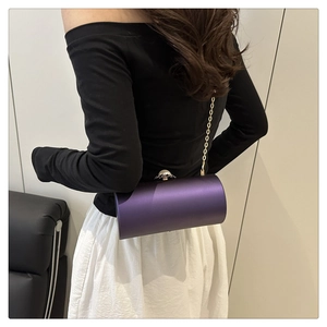 Vue détaillée du sac de soirée cylindrique violet en satin avec chaîne dorée