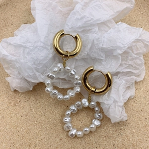 Detailed view of vintage gold hoop earrings with irregular white pearl circular pendants