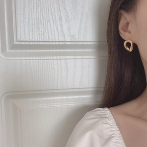 Elegant gold geometric irregular earrings for women worn on ear in minimalist modern style