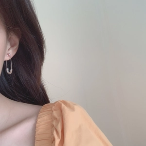 Boucles d'oreilles épingle à nourrice en argent portées par un mannequin chic