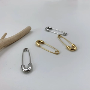 Vue détaillée de boucles d'oreilles épingles à nourrice dorées et argentées