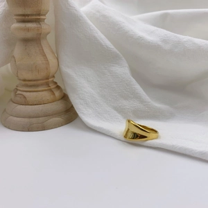 Detailed close-up of golden irregular wavy ring with a mirror-polished surface