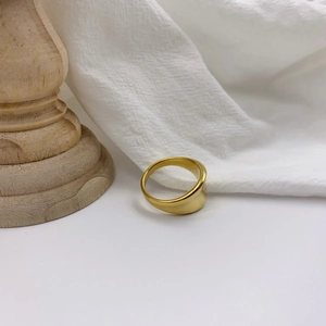 Minimalist gold irregular concave ring with polished finish on vintage wooden base