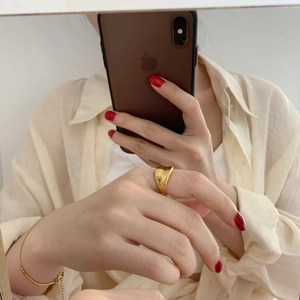 Minimalist gold wave wide ring with irregular concave design for women on a polished surface