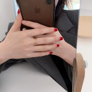Detailed view of the gold nail-shaped wrap ring with a polished metallic finish
