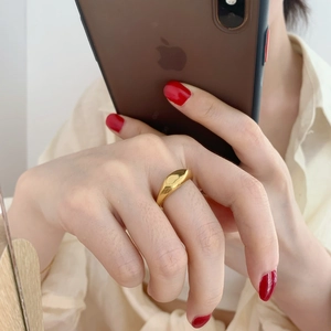 Polished gold minimalist ring on model finger with a glossy mirror finish detail