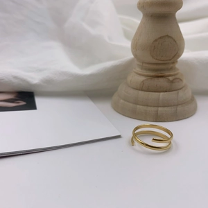 Macro view of minimalist 18k gold double-layered spiral ring with a polished mirror finish