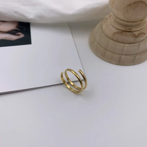 Macro detail of minimalist double-layered 18k gold plated spiral ring with mirror finish
