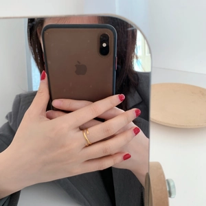 Close-up of minimalist layered golden stainless steel open ring worn on index finger