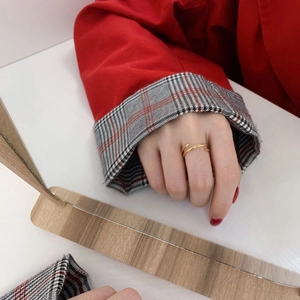 Golden multi-layer spiral ring worn on finger featuring a polished minimalist finish