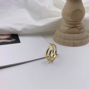 Detail of 18k gold plated multi-layer spiral ring on a minimalist white display