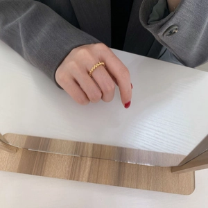 Primo piano dell'anello con perline dorate indossato sulla mano di una modella