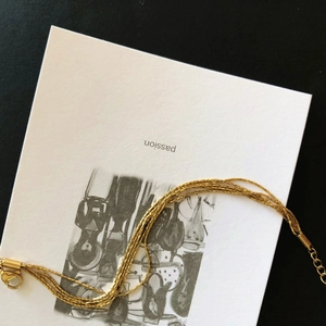 Minimalist multi-strand gold titanium steel bracelet for women shown on an artistic card
