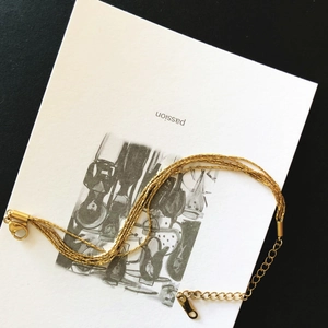 Detail of layered gold titanium steel bracelets with lobster clasp and adjustable chain