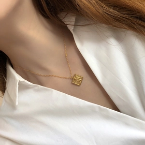 Élégant collier en or 18 carats avec pendentif ange carré porté par un mannequin