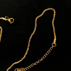 Detailed close-up of 18K gold-plated snowflake chain necklace with K18 engraved tag
