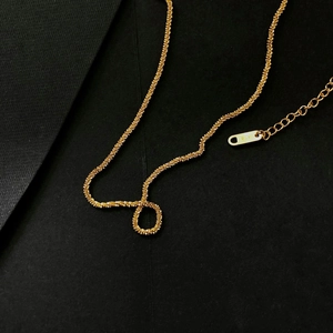 Detail of 18K gold necklace with spiral chain texture and K18 hallmark engraving