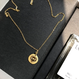 Dettaglio della collana con ciondolo Evil Eye dorato su una scatola regalo nera di lusso