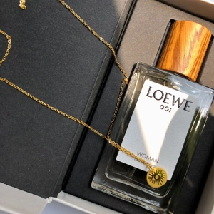 Collana con occhio greco dorata su portagioie con profumo per un look elegante