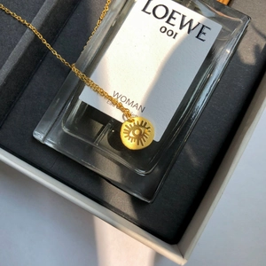 Collana minimalista dorata con ciondolo occhio greco su una scatola di gioielli
