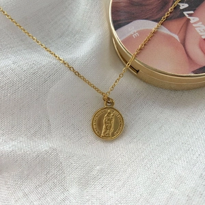 Golden medallion necklace featuring Virgin Mary portrait relief on a delicate chain