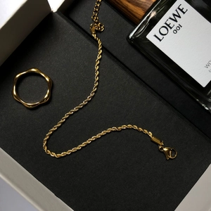 Bracelet chaîne dorée et bague vague présentés dans un coffret cadeau noir