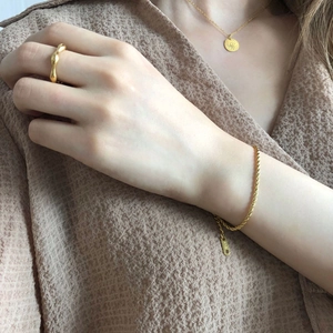 Détails du bracelet K18 en or torsadé et collier avec pendentif œil sur un mannequin