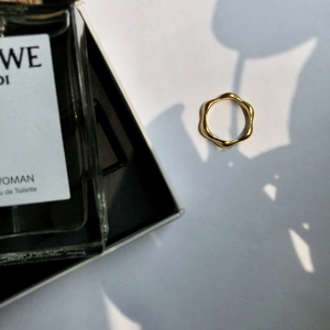 Chic gold wave ring with polished finish displayed in an aesthetic setting with shadows